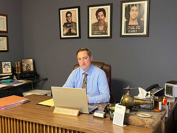 Photo of attorney John A. Powers sitting at desk