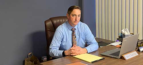 Photo of attorney John A. Powers sitting at desk